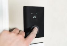 Fűtéskorszerűsítés okos megoldásokkal Modern okos termosztát felhasználói felülettel a falon, fűtéskorszerűsítéshez